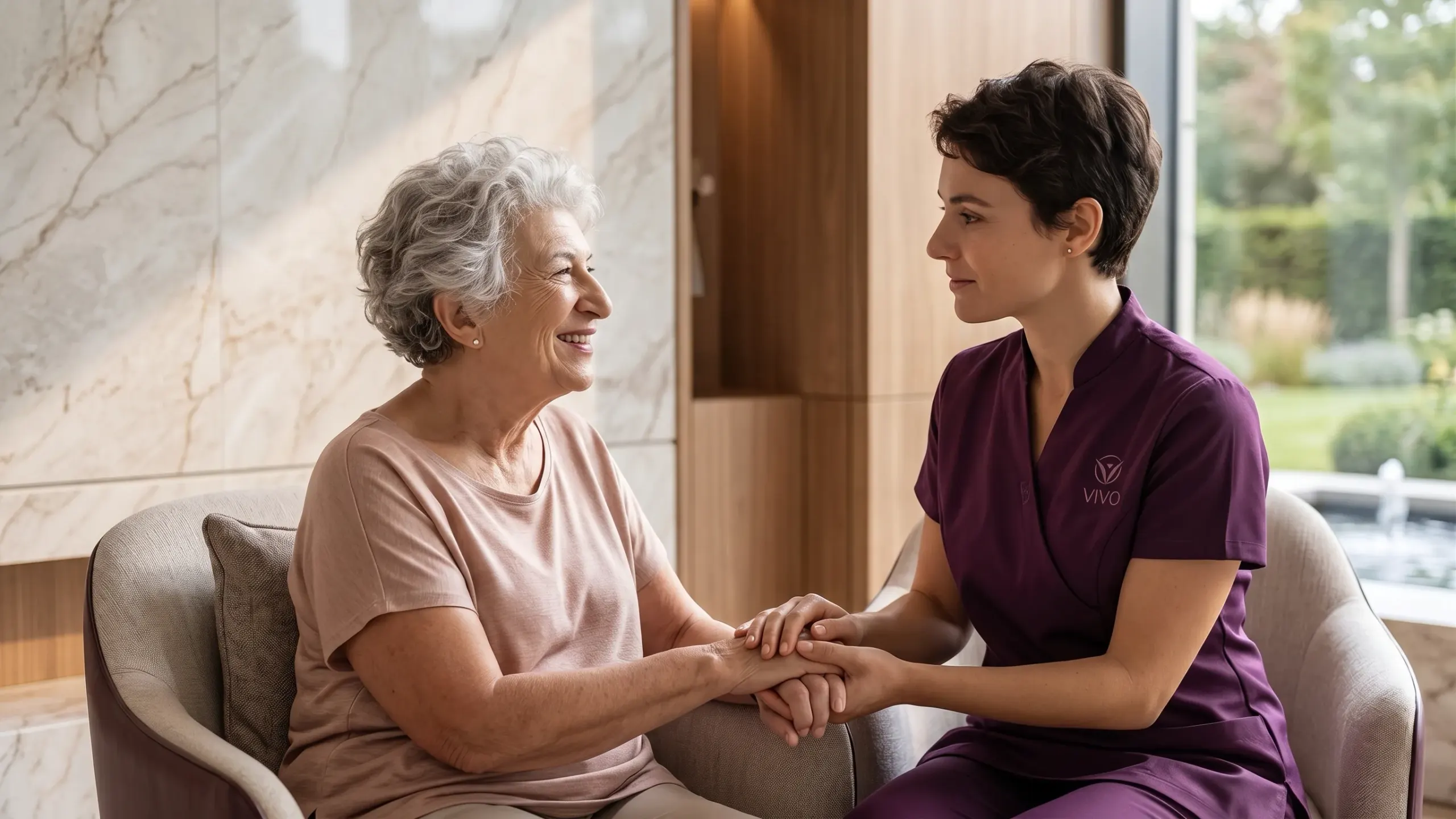 A caregiver holding hands with a resident during a warm one-on-one moment